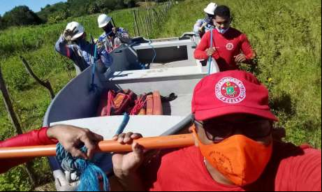 Equipe do Corpo de Bombeiros conduz funcionários da Enel sobre as águas de um riacho. Foto: Ascom/Corpo de Bombeiros 