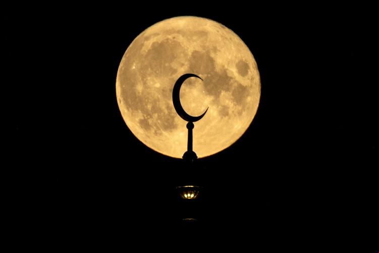 Uma lua cheia aparece sobre o Sobornaya, a Mesquita da Catedral de Moscou em Moscou, em 22 de agosto de 2021