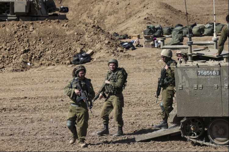 Soldados israelenses perto de seus veículos blindados estacionados em um campo ao longo da fronteira Israel-Gaza em 15 de outubro de 2023
