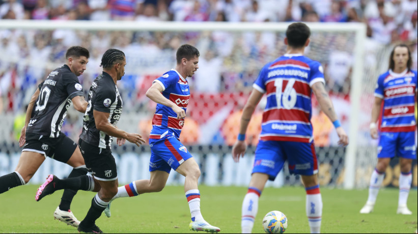 Matheus Rossetto conduz a bola sendo marcado por Fernando Sobral e Mugni