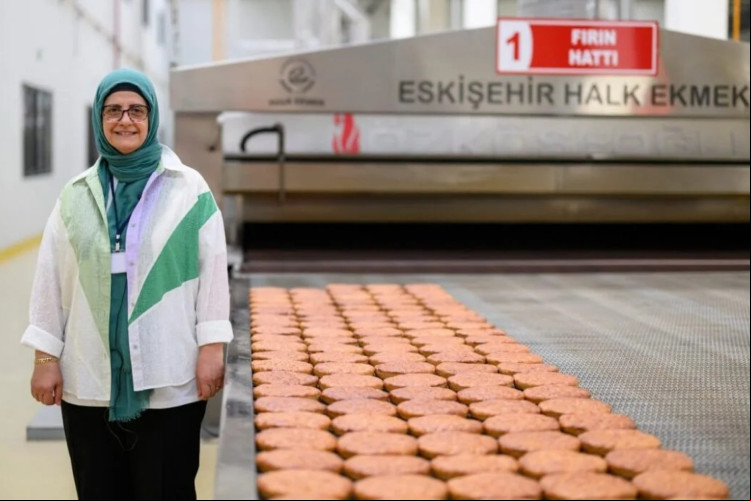 Serap Güler, gerente da Halk Ekmek (Pão Público, em turco) ao lado de pães Kulluoba cozidos, uma reprodução de um pão de 5.000 anos. Serap Güler, gerente da Halk Ekmek (Pão Público, em turco) ao lado de pães Kulluoba cozidos, uma reprodução de um pão de 5.000 anos.