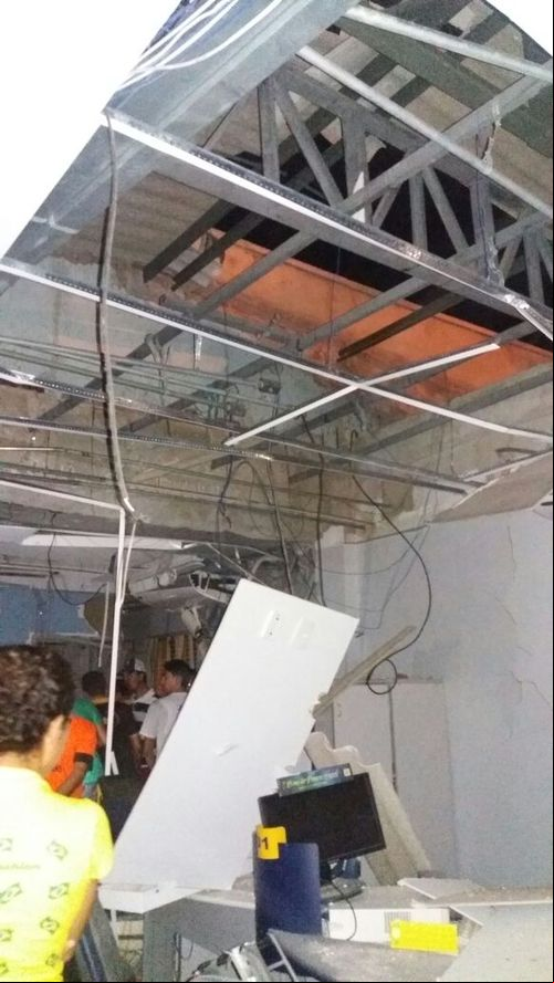 Pessoas no banco testemunhando a destruição da agência após as explosões.  